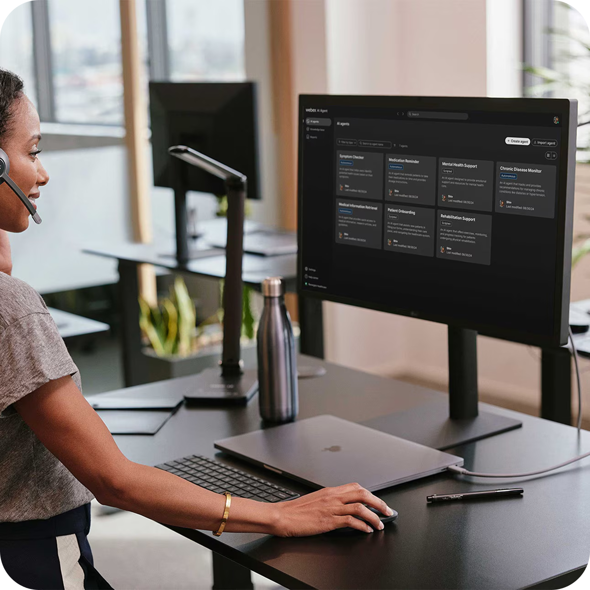 En agent i kontaktcenteret står ved et skrivebord og betjener Webex AI Agent på en skærm.